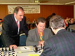 Dr. Trümper versucht sich gegen Dr. Jordan im Schach, beobachtet von Fassbender